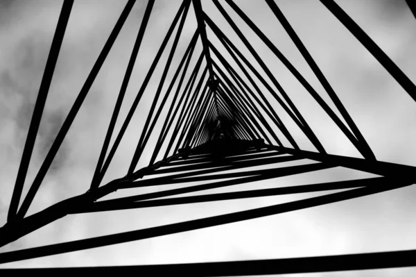 Nízký Úhel Záběru Kovové Věže Stupních Šedi Vytvářející Trojúhelníkový Vzor — Stock fotografie