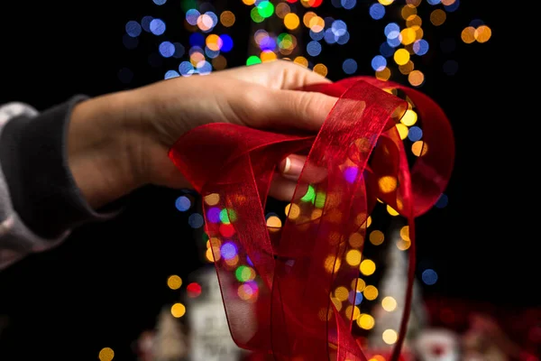 Closeup Shot Person Holding Red Ribbon Colorful Bokeh Background — Stock Photo, Image