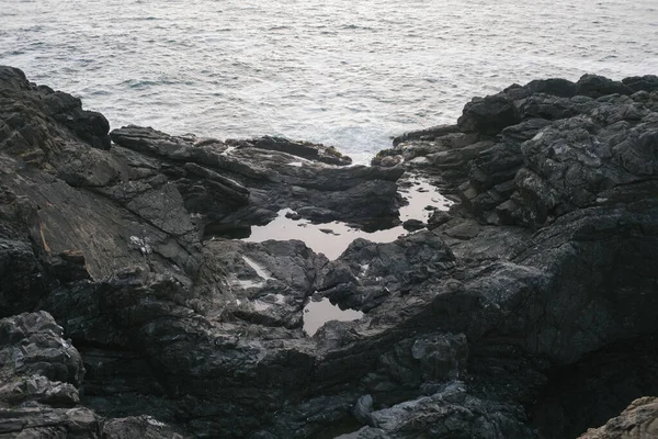 Uma Costa Rochosa Cercada Pelo Mar Luz Dia — Fotografia de Stock