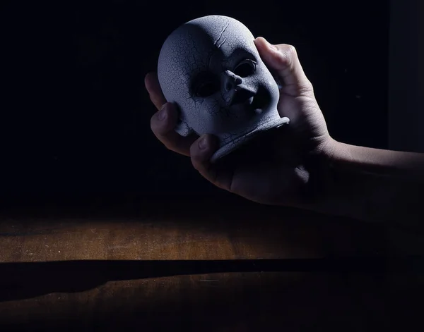 Una Mano Sosteniendo Espeluznante Cráneo Niño Oscuridad —  Fotos de Stock