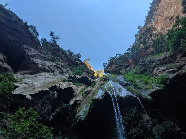Tiro Ângulo Baixo Uma Cachoeira Cercada Por Rochas Vegetação Dia — Fotografia de Stock
