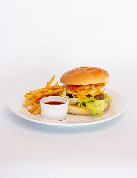ハンバーガーの垂直ショット 白の背景にソースとフライドポテト — ストック写真