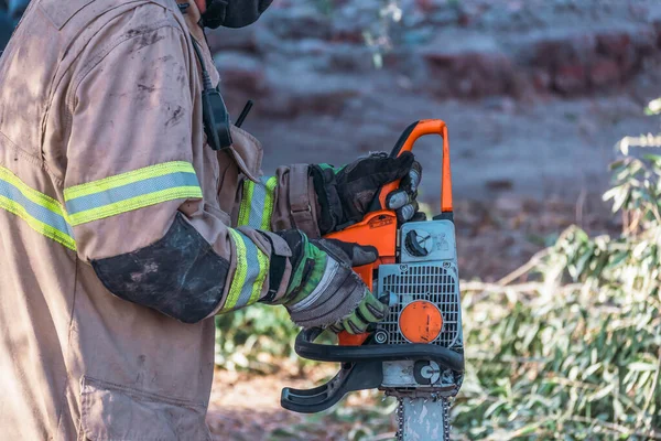 Seorang Pemadam Kebakaran Memulai Gergaji Mesin Dalam Penyelamatan — Stok Foto