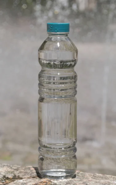 Uma Garrafa Transparente Água Uma Superfície Rochosa — Fotografia de Stock