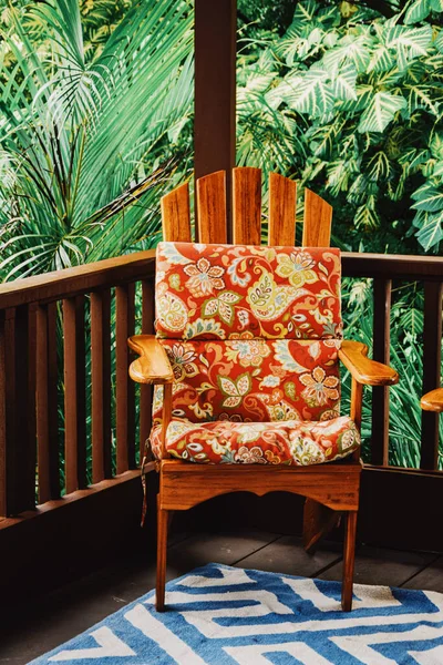 露台上有彩色花纹靠垫的木制椅子的垂直截图 — 图库照片