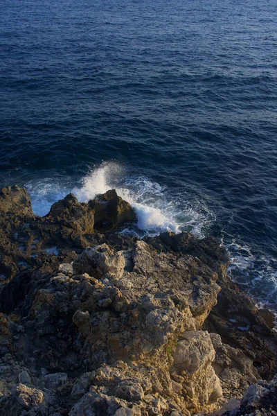 Colpo Verticale Una Riva Rocciosa Circondata Dal Mare Sotto Luce — Foto Stock