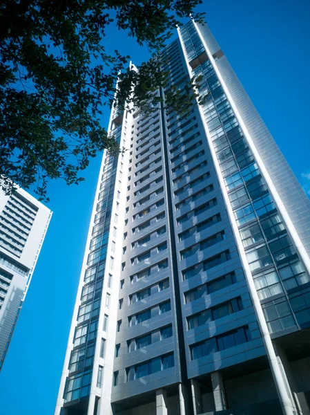 青い空の背景に現代の超高層ビルの垂直ショット — ストック写真