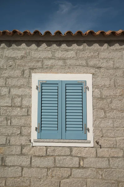 用蓝色木制百叶窗封在旧砖墙中的窗户 — 图库照片
