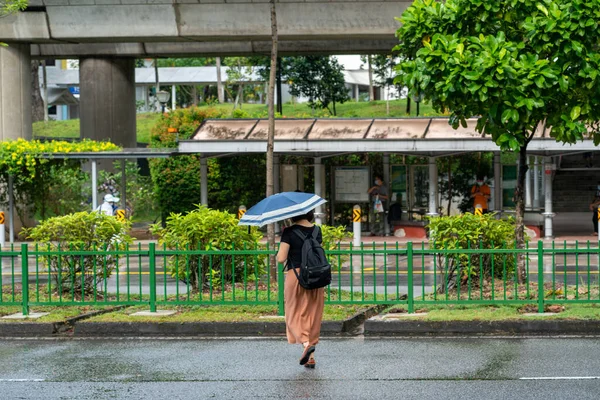 シンガポール シンガポール 2021年9月19日 シンガポールのYishunで雨の日に道路を横断する女性 水平射撃 — ストック写真