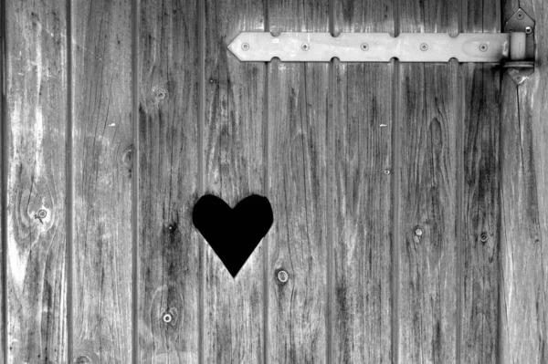 Серый Снимок Отверстия Форме Сердца Деревянном Фоне — стоковое фото
