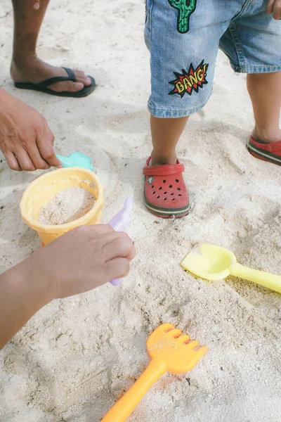 Вертикальный Снимок Детей Играющих Красочные Пляжные Игрушки Белом Песке Травянистый — стоковое фото