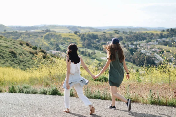 Par Amigas Cogidas Mano Caminando Cerca Colinas Campos — Foto de Stock