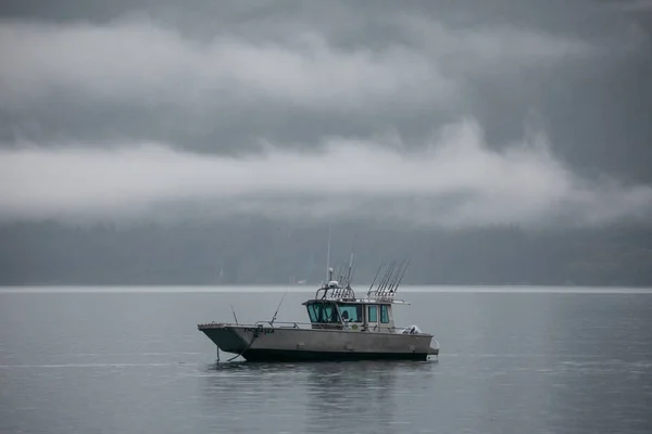 アラスカの霧深い朝に丘や山に囲まれた湖を航海する漁船 — ストック写真