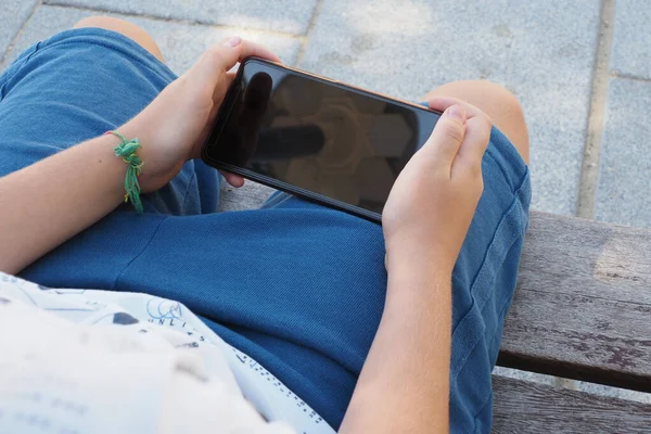 Garçon Assis Sur Banc Bois Tenant Son Smartphone Noir — Photo