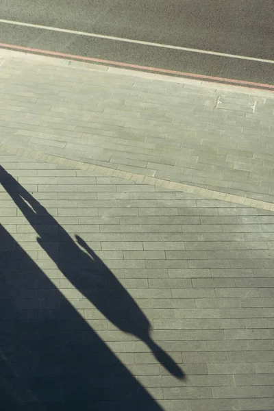 Ein Schatten Eines Mannes Auf Dem Kopfsteinpflaster Eines Fußweges Der — Stockfoto