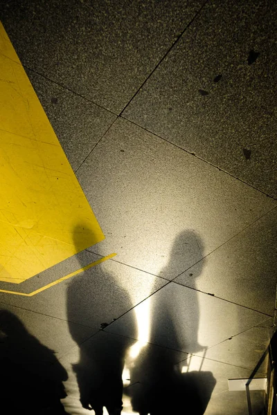 Tiro Vertical Das Sombras Das Pessoas Segurando Suas Malas Chão — Fotografia de Stock