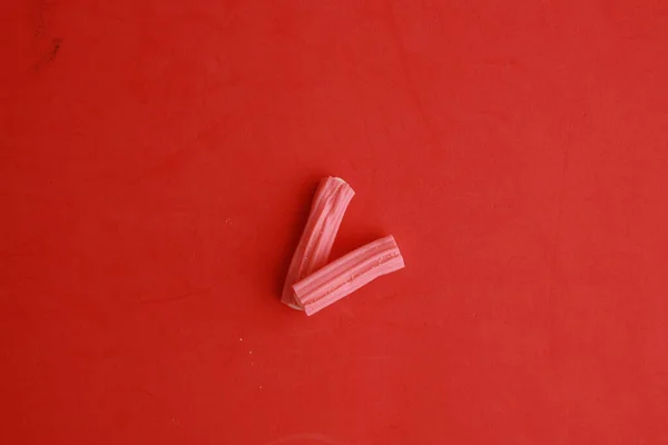 Delicioso Alcaçuz Geleia Rosa Branco Uma Superfície Vermelha — Fotografia de Stock