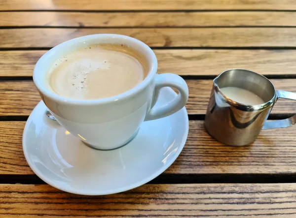 Closeup Shot White Cup Coffee Small Can Milk Wooden Table — Stock Photo, Image