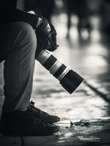 Fechamento Vertical Escala Cinza Fotógrafo Sentado Rua Segurando Câmera — Fotografia de Stock