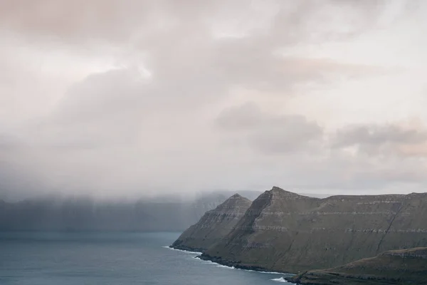 法罗群岛悬崖峭壁在雾中 晨曦的斯堪的纳维亚风景 高山覆盖 雾笼罩峡湾 北欧景观 — 图库照片