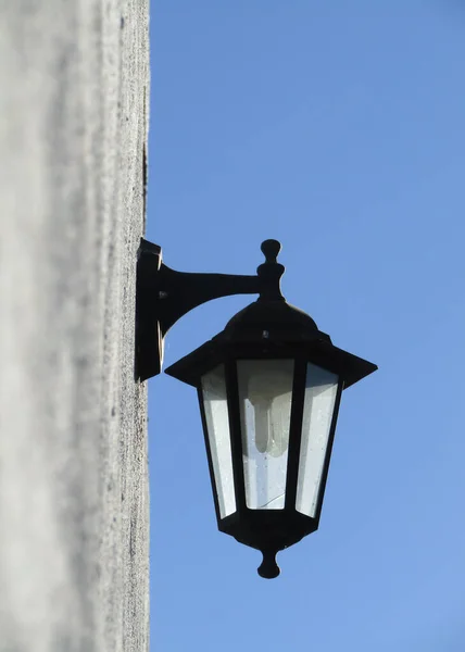 Вертикальный Снимок Уличной Лампы Стене Против Голубого Ясного Неба — стоковое фото
