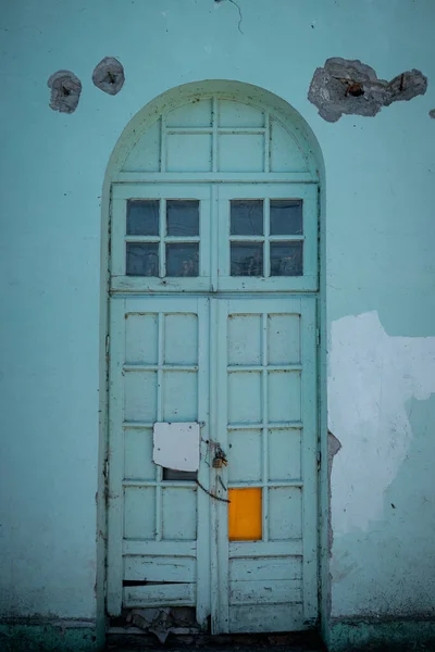 Eine Schäbige Antike Holztür Einer Hellblauen Wand Mit Einschusslöchern — Stockfoto