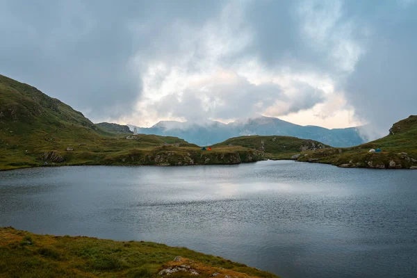 美丽的湖景被多云的天空下的青山环绕着 — 图库照片