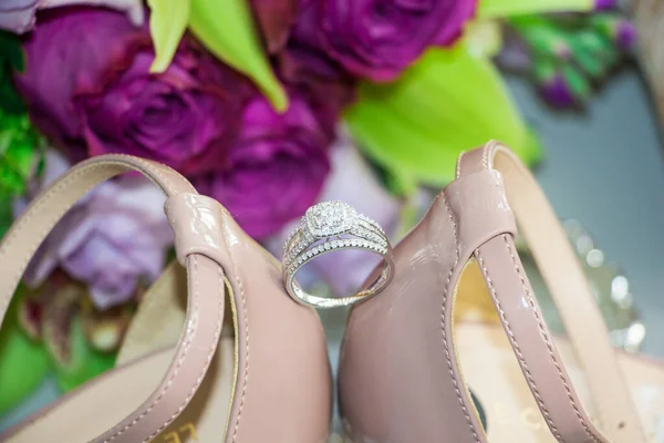 Eine Nahaufnahme Von Schönen Hochzeitsschuhen Mit Einem Ring Und Blumenstrauß — Stockfoto