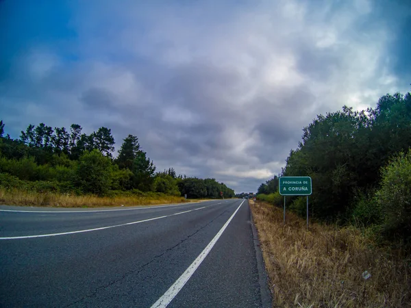 Widok Autostradę Otoczoną Trawą Roślinami Drzewami Oraz Znak Drogowy Ponury — Zdjęcie stockowe