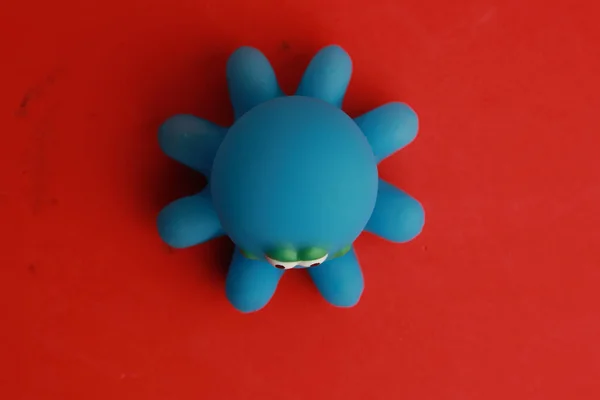 Brinquedo Infantil Uma Banheira Polvo Azul Uma Superfície Vermelha — Fotografia de Stock