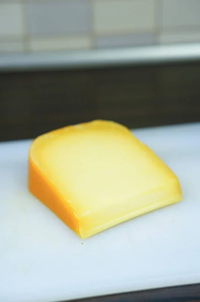 Großaufnahme Eines Stücks Gouda Käse Auf Dem Schneidebrett Aus Kunststoff — Stockfoto