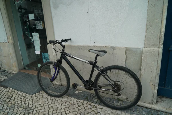 一辆黑色的旧自行车停在墙边 — 图库照片