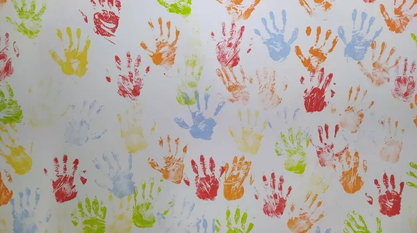 Colorful handprints on a white wall