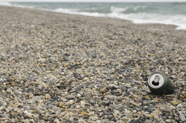 Puszka Napoju Kamieniach Żwirowych Plaży Tłem Fali Morskiej Ponury Dzień — Zdjęcie stockowe