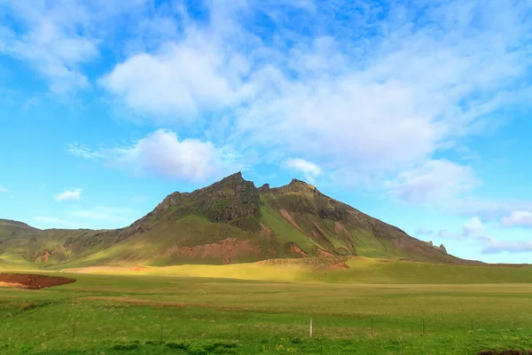 アイスランドの牧草地と青空を背景にした山々の美しい景色 ストック写真