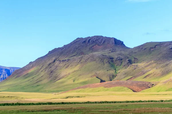 アイスランドの牧草地と青空を背景にした山々の美しい景色 — ストック写真