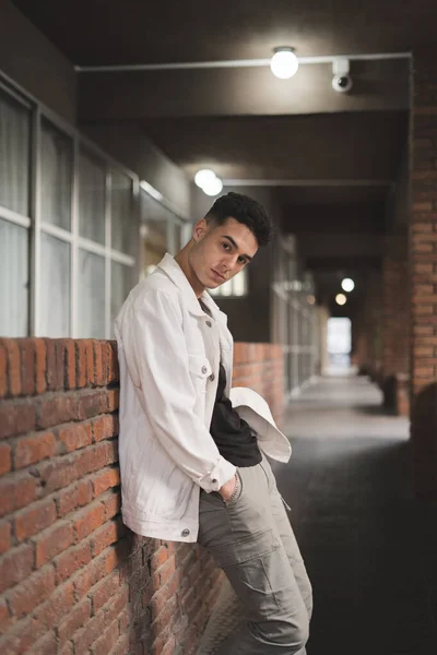 Vertical Shot Young Stylish Caucasian Man White Jacket Leaning Brick — стоковое фото