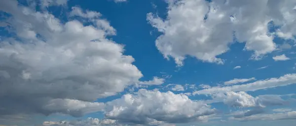 明るい青空の上に美しいふわふわの雲の低角度ショット — ストック写真