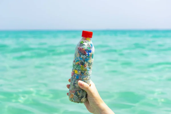 Hand Holding Bottle Filled Microplastics Collected Sea Sea Background Concept — Stock Photo, Image