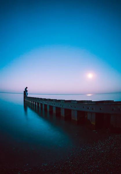 黄昏时一个人站在船坞边的风景 — 图库照片