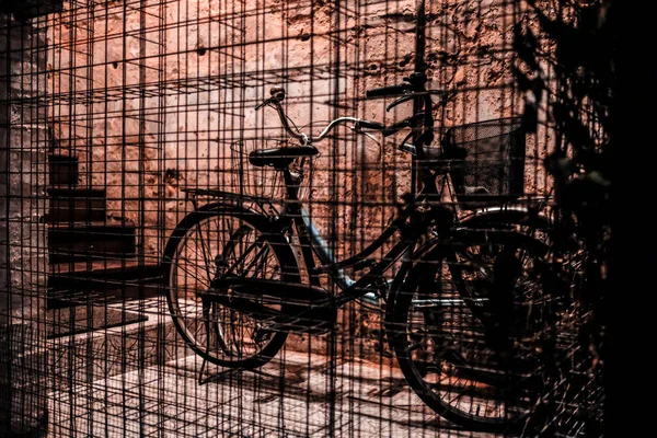 Uma Bicicleta Estacionada Por Uma Cerca Frente Uma Parede Noite — Fotografia de Stock