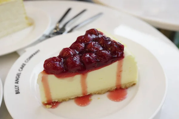 白い皿に果実とチーズケーキのおいしいスライスのクローズアップショット — ストック写真