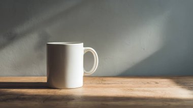 Temiz beyaz bir kupa, ahşap bir yüzeyde, yumuşak, rahatlatıcı gölgeler ve atmosfer yaratan, doğal güneş ışığıyla aydınlatılmış, zarif bir şekilde oturmaktadır..