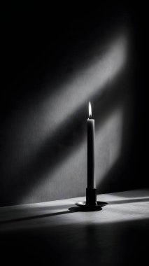 Yalnız beyaz bir mum, koyu bir arka planda parlar, dokulu bir yüzeye uzun ve dramatik bir gölge bırakır..