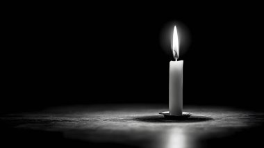 Yalnız beyaz bir mum, koyu bir arka planda parlar, dokulu bir yüzeye uzun ve dramatik bir gölge bırakır..