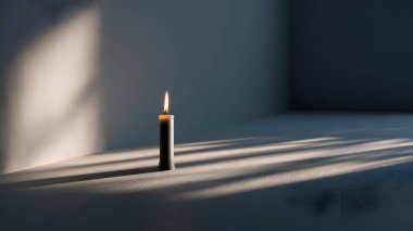 Sıcak, parıldayan bir mum desenli bir yüzeye oturur. Yakınlardaki bir pencereden geçen güneş ışığıyla güzelce aydınlatılır..