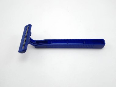 Ustura gibi keskin kenarları olan tek kullanımlık mavi bir tıraş makinesi.