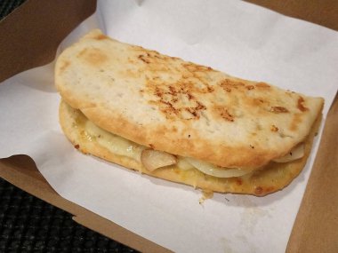 Peynirli ve diğer malzemeli pizzalı sandviç.