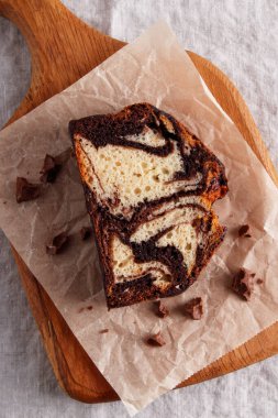 Parşömen kâğıdında çikolata kıvrımlı mermer pasta, kırsal tatlı, ahşap arka plan.