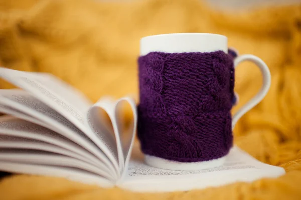 Трикотажная чашка с открытой книгой — стоковое фото